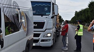 Przedstawiciel kampanii wręcza kierowcy materiały informacyjne kampanii