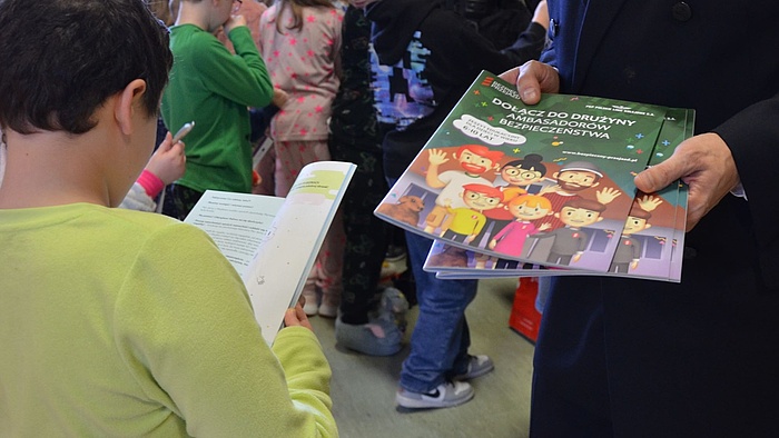 Dzieci przeglądają książeczki edukacyjne kampanii 
