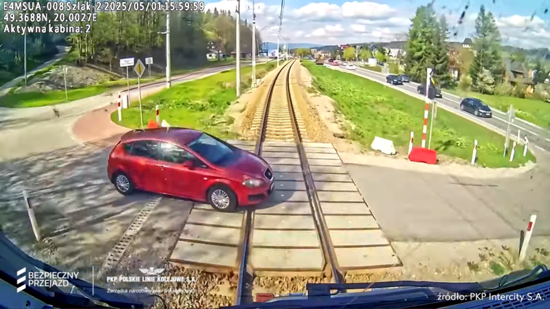 Widok z kabiny maszynisty na samochód na przejeździe, chwilę przed uderzeniem.