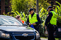 Funkcjonariusze SOK wręczający materiały informacyjne kierowcy w samochodzie
