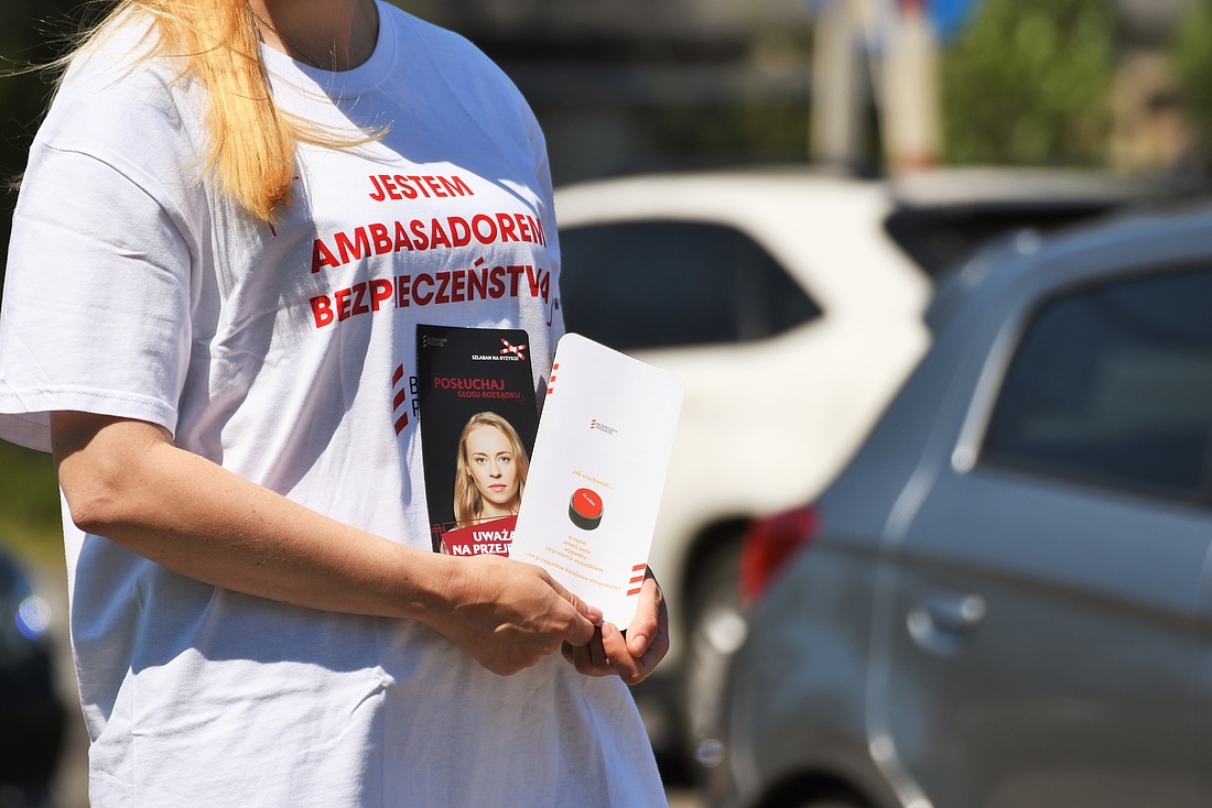 Akcja ulotkowa na przejeździe, przejeżdżające samochody przez tory