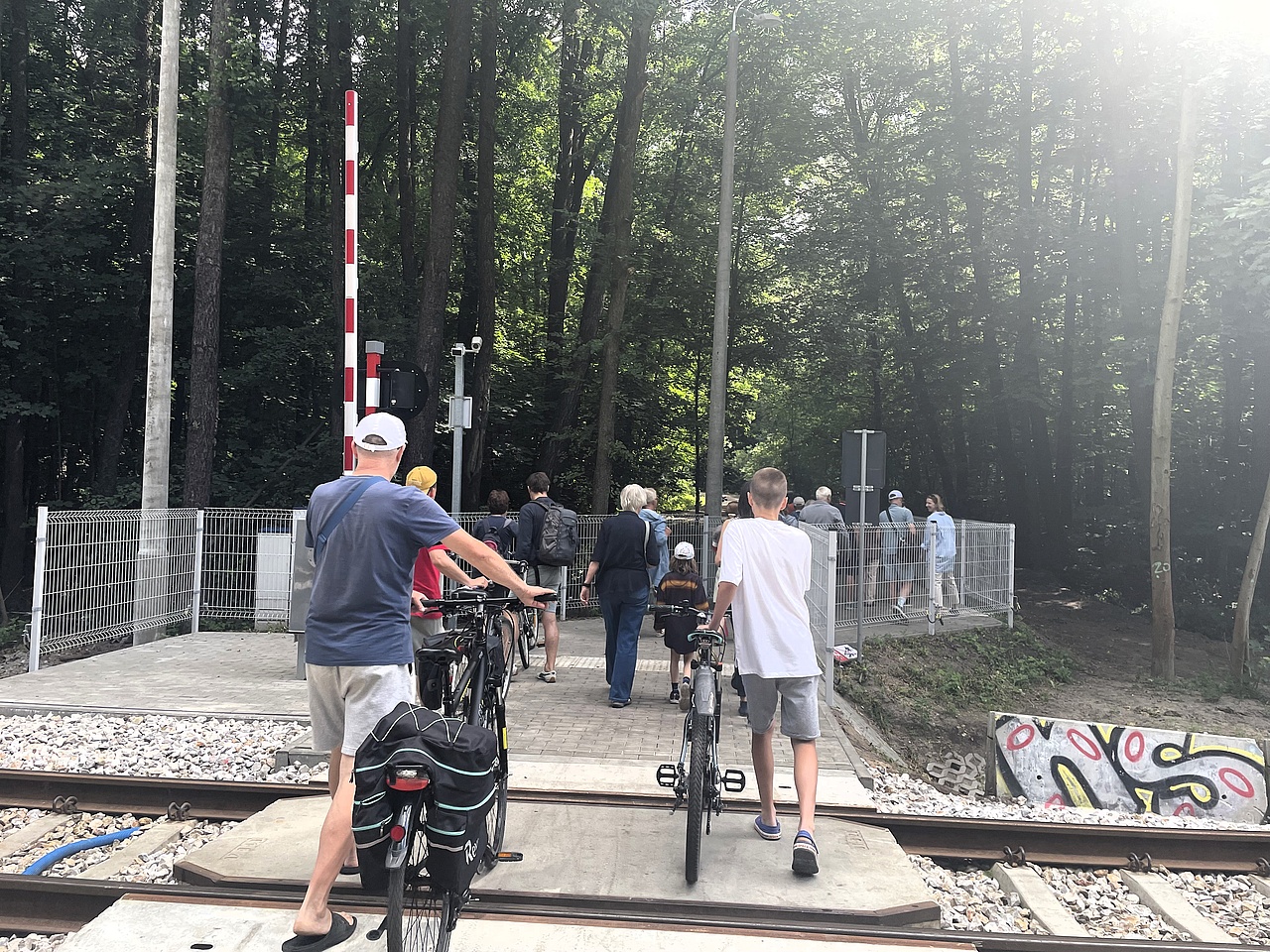 Rowerzyści przeprowadzają rower przez przejście na torach