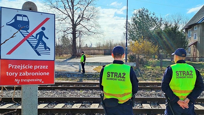 Funkcjonariusze SOK przy torach, znak "Przejście przez tory zabronione.