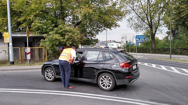 Przedstawiciel kampanii wręcza ulotkę kierowcy w samochodzie