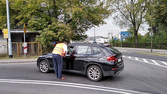 Przedstawiciel kampanii wręcza ulotkę kierowcy w samochodzie