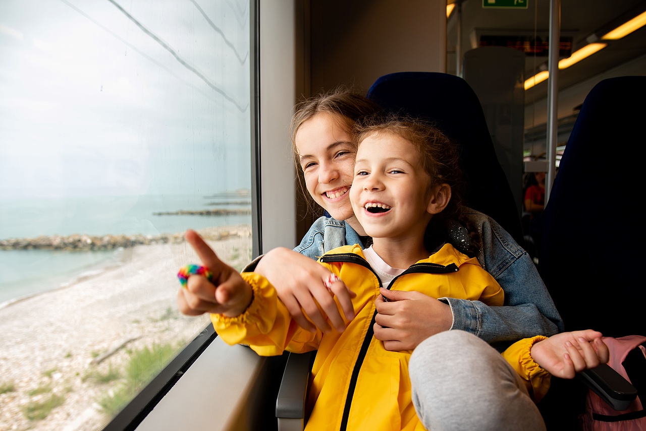 Chłopiec i dziewczynka w siedzący w pociągu i oglądający świat za oknem.