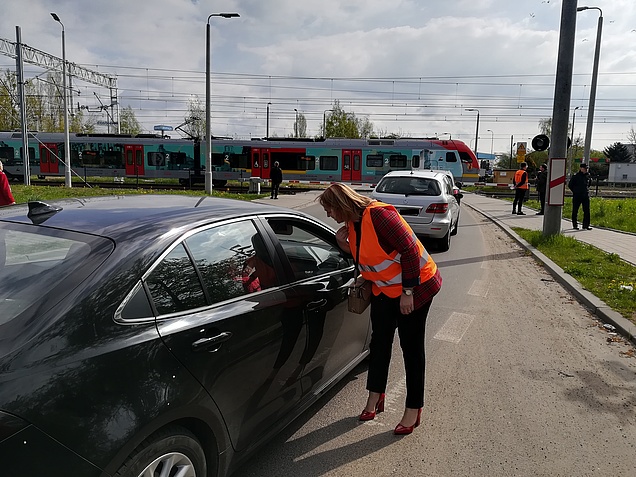 Przedstawiciele PLK SA rozmawiają z kierowcami przed przejazdem kolejowo-drogowym w Łodzi; fot. Rafał Wilgusiak