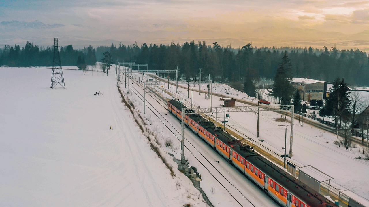 Widok z drona na pociąg na trasie Chabówka - Zakopane w zimowej scenerii.