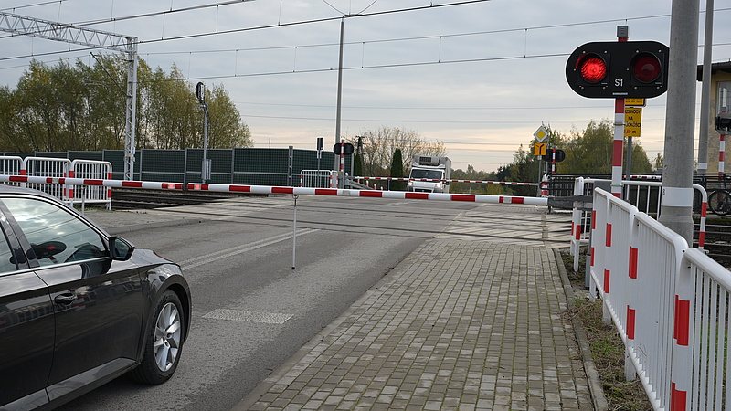 Samochód stojący przd zamkniętym szlabanem na przejeździe kolejowo-drogowym Łowicz - Myślaków