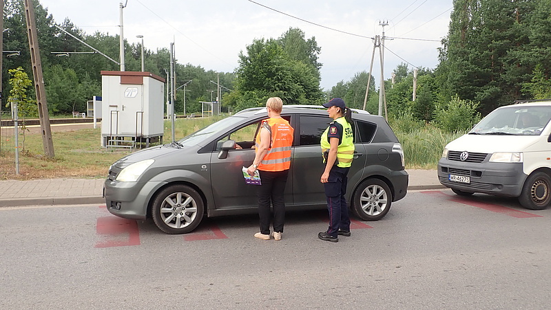 Przedstawicielki SOK i kampanii obok samochodu stojącego przed przejazdem.